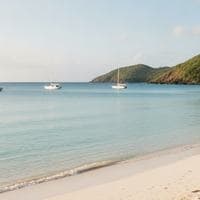 Sailboats anchored off a quiet Caribbean beach